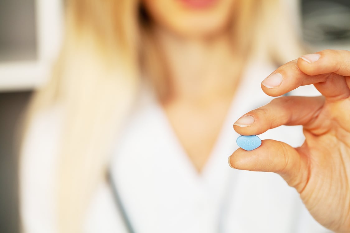 Close up of female doctor holding pill for men health